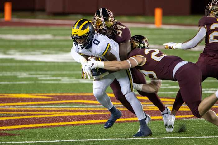 Oct 24, 2020; Minneapolis, Minnesota, USA; Michigan Wolverines wide receiver Giles Jackson (0) catches a pass and gets tackled from Minnesota Golden Gophers defensive lineman Boye Mafe (34) and Minnesota Golden Gophers defensive back Matt Guggemos (28) in the first quarter at TCF Bank Stadium. Mandatory Credit: Jesse Johnson-USA TODAY Sports